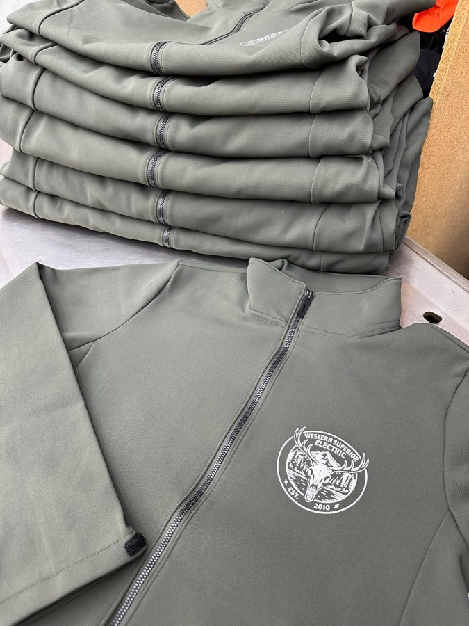 Stack of gray full-zip jackets with a white left-chest logo