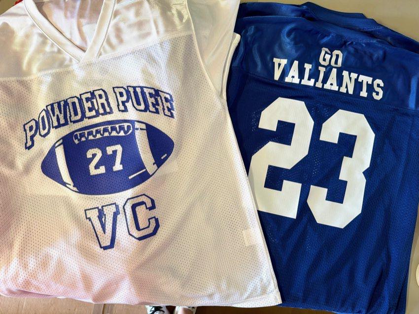White and navy Powder Puff football jerseys with VC and Go Valiants lettering and player numbers