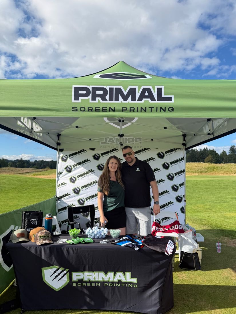 The owners of Primal Screen Printing at the company's branded tent at a local event