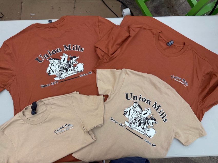 Orange and tan t-shirts printed with the illustrated Union Mills logo